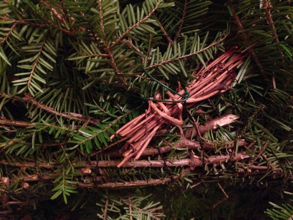 Start the grapevine garland by twisting it securely with a piece of florist wire at the back of the wreath.