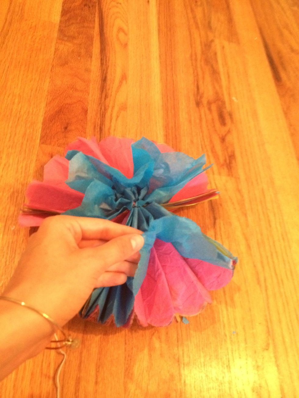 Start to slowly pull each piece of paper out to form a ball shape.