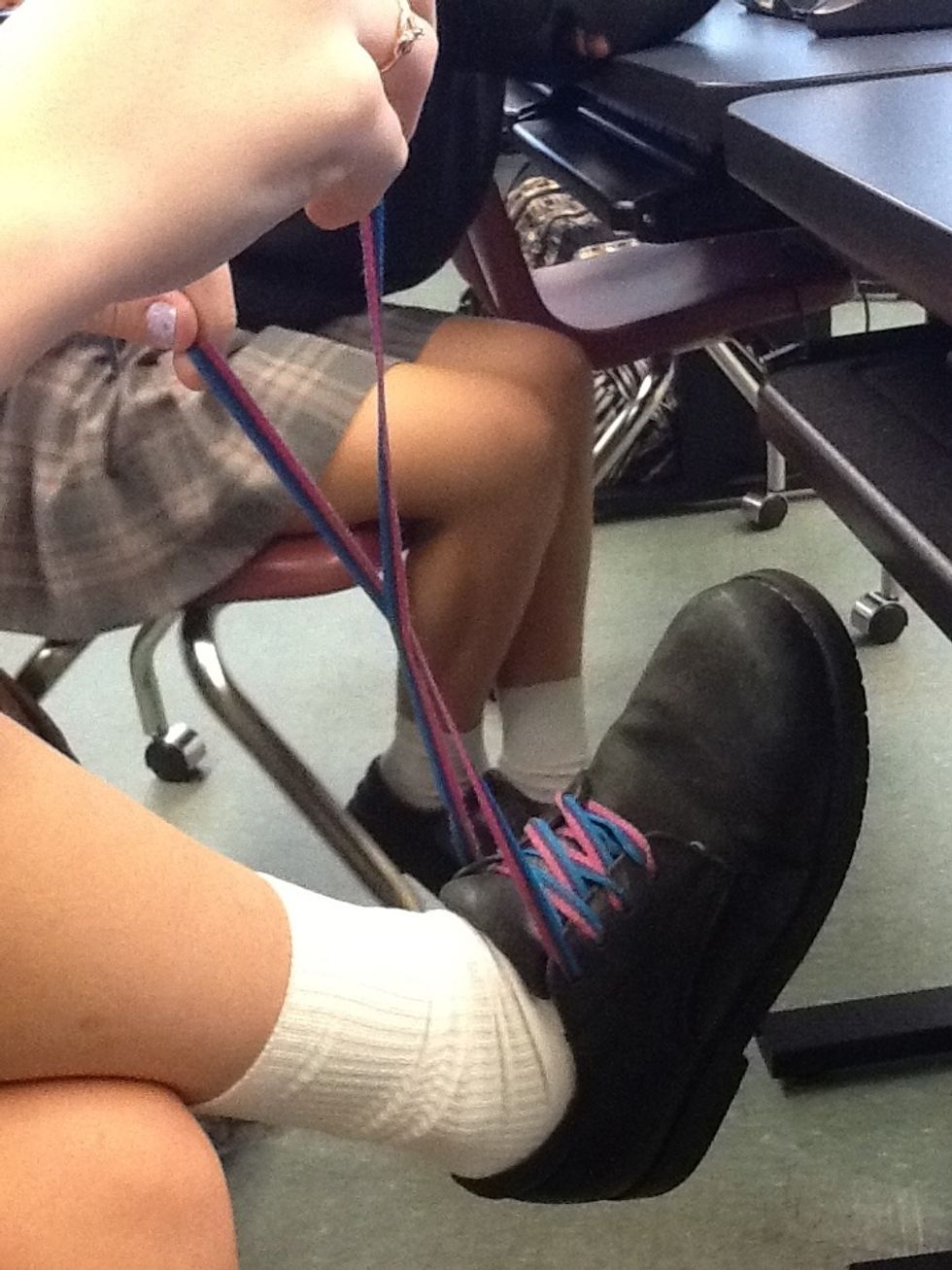 Start to tie your shoe by crisscrossing the laces