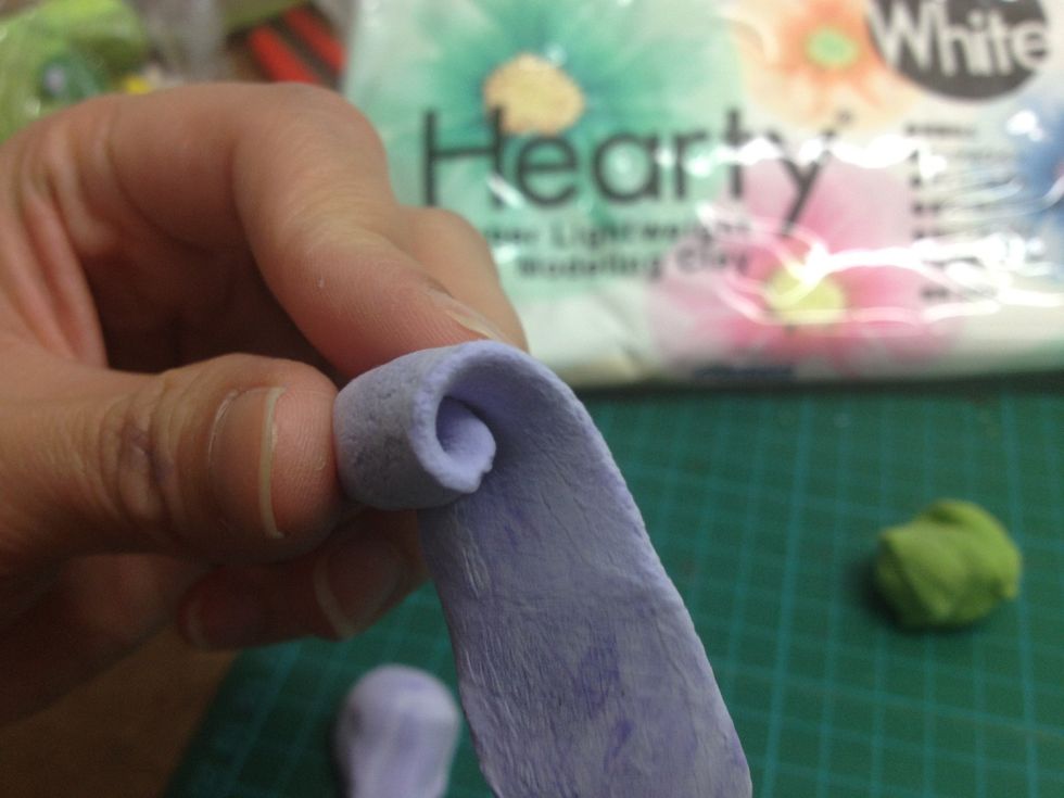 - Start turning the clay around the pencil tip to make the rose middle part.