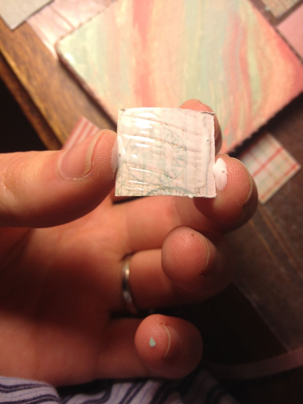 Start with a corner square. Add a thin layer of mod podge (this is too much) to the back and glue it carefully down. It should have very thin margins with the edges. (See next)