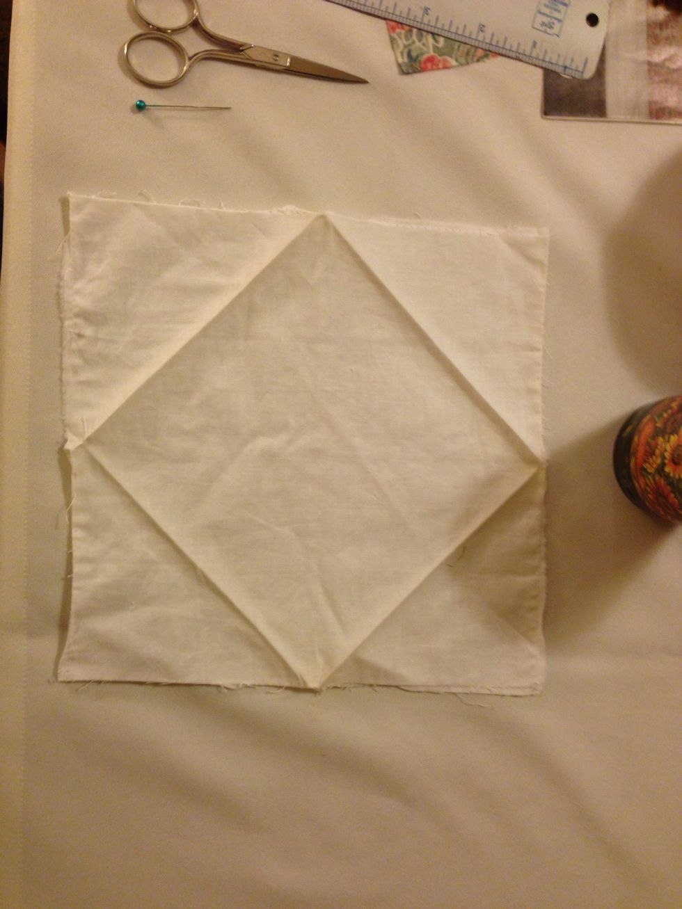 Start with an eight and a half inch square of fabric. Turn it inside out and pin up one side.