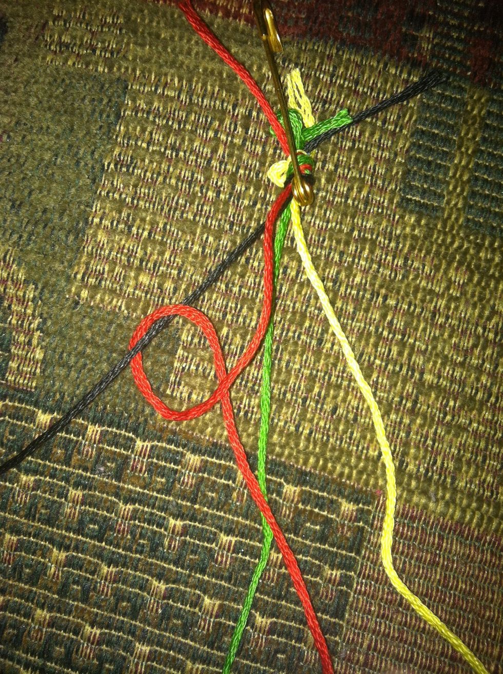 Start with String 1 (red) and pass it over, then under String 2 (black). Pull string 1 through the loop you've created, and pull the knot snug. Remember to double knot!