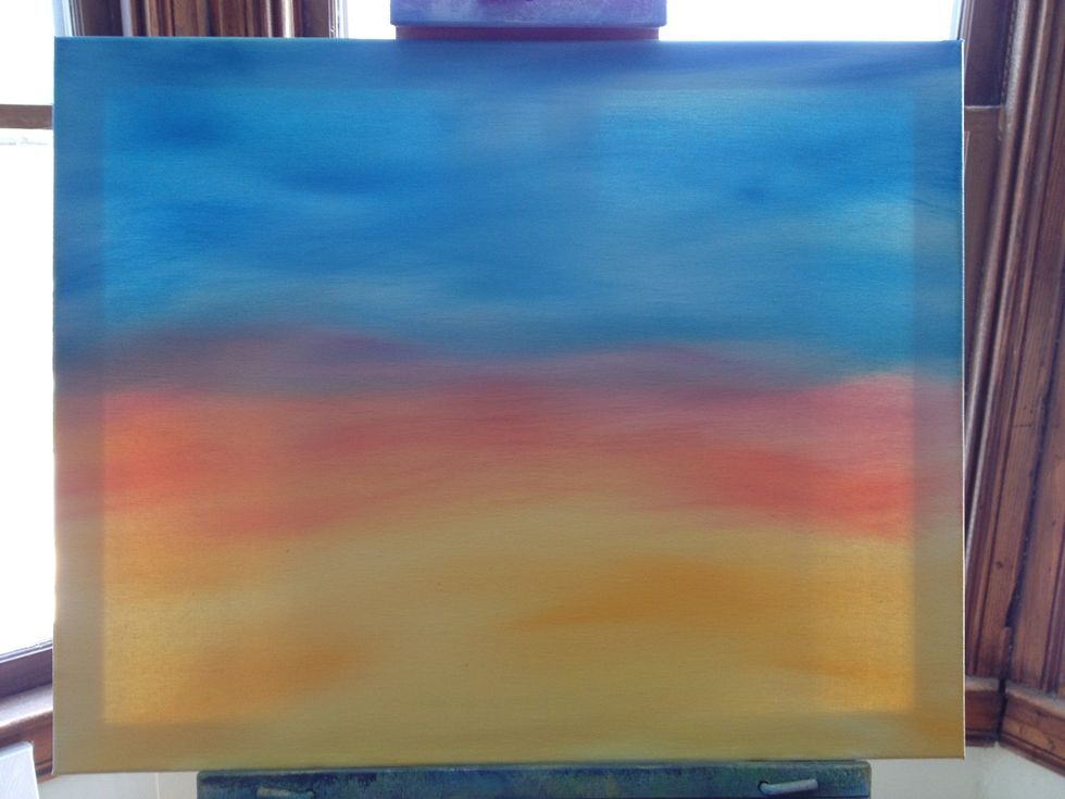 Start with yellow on a chip brush, making little X patterns across the bottom of the canvas. Slowly introduce some red to your mix as you go up the canvas. Then crimson. Switch brushes for the blue.