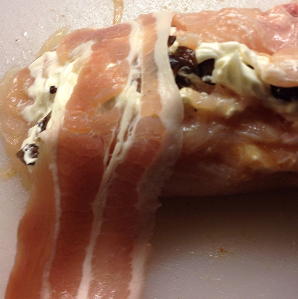 Start wrapping the breast by placing the end of the bacon around the gap of the breast like so. It may take about 3-4 rashers to cover it and wrap tightly.