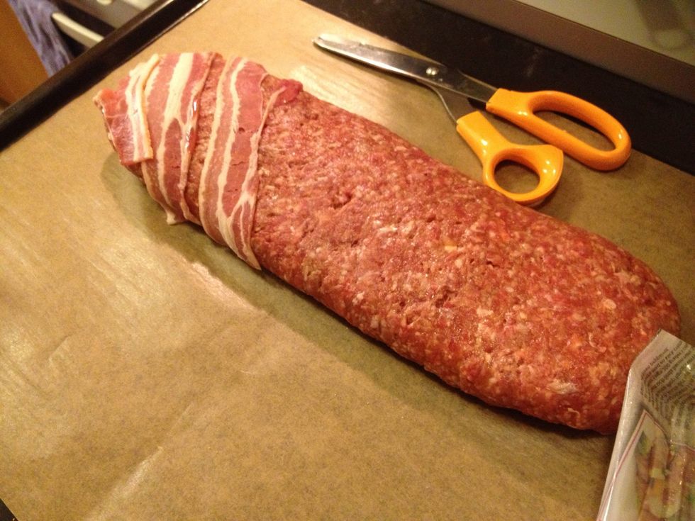 Start wrapping the meatloaf with the bacon.