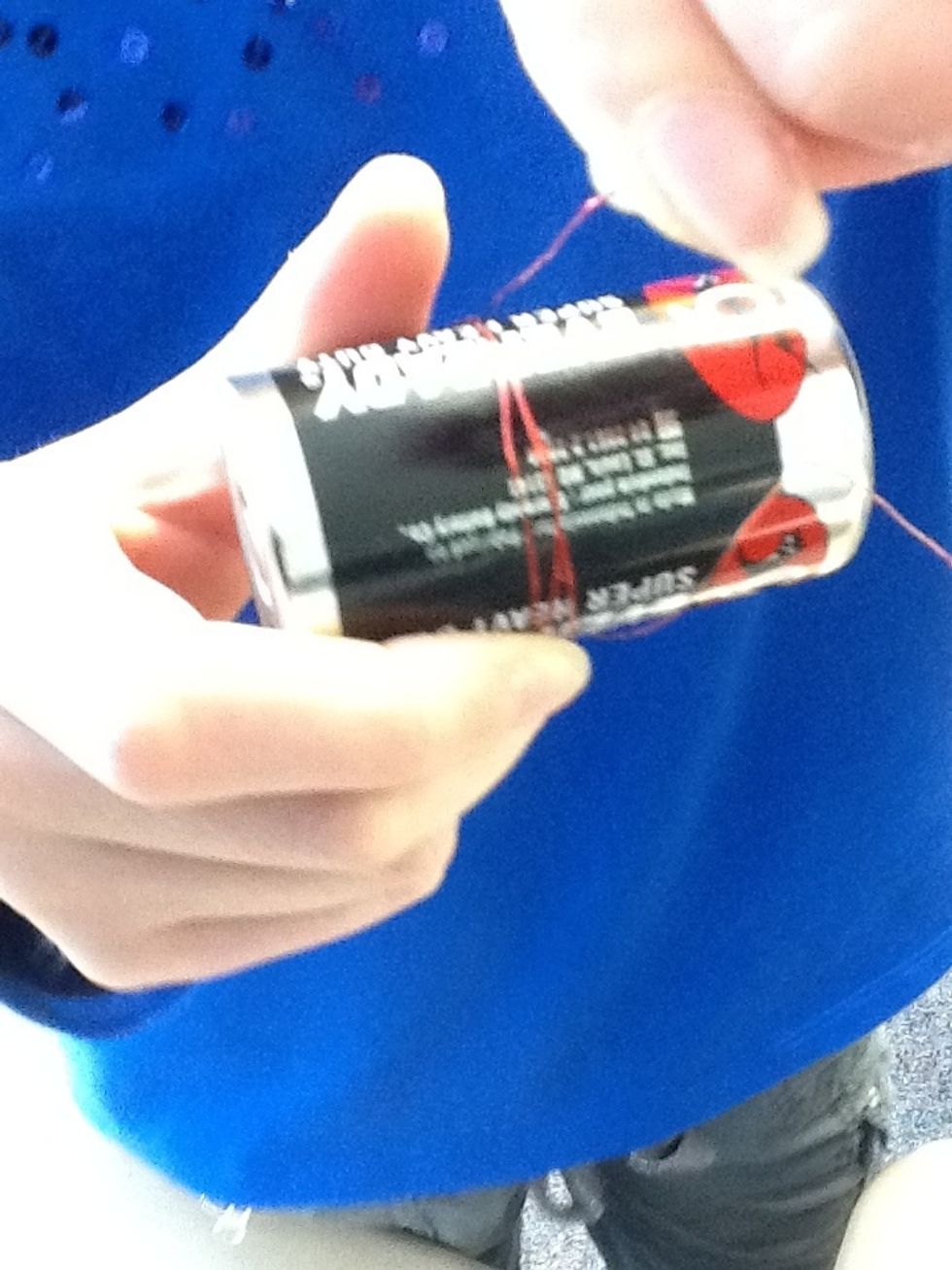 Start wrapping the red part of the red wire around the battery to the other side, stopping at the copper part.