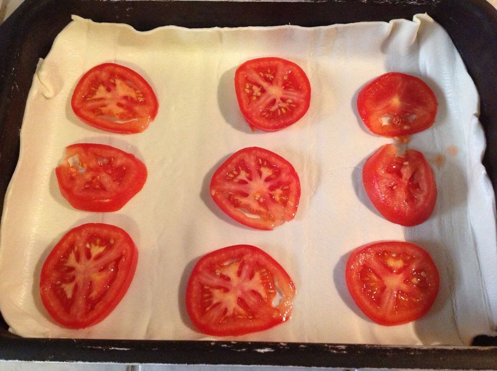 Start your pizza by distributing the tomatoes evenly.