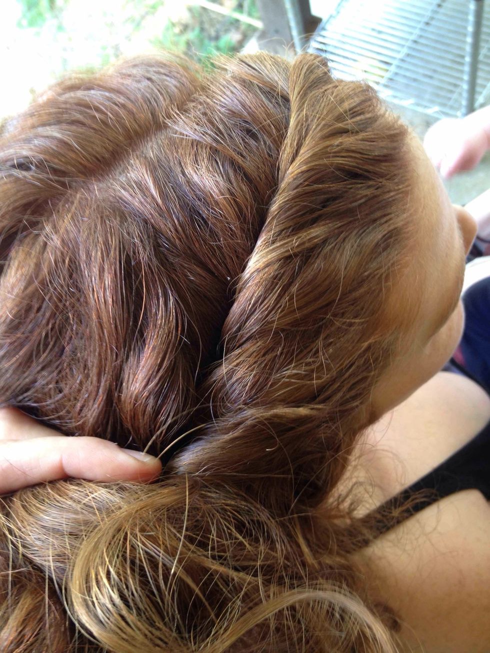 Starting at the hairline on one side of the part, take a small bit of hair and twist it towards the top of the head. Add a little bit of hair from underneath and twist again.