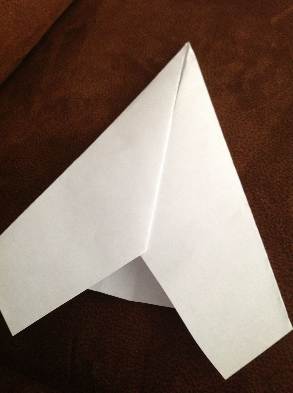 Starting at the very tip of the point, fold the paper over on each side so the inside edges line up with the center crease.