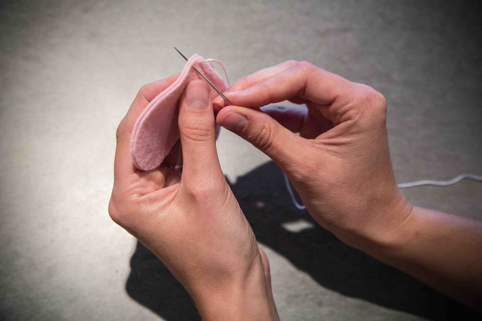 Starting from the side opposite of the knot, stick the needle roughly 3mm through both layers of felt. Pull the embroidery floss through, but not all of the way.