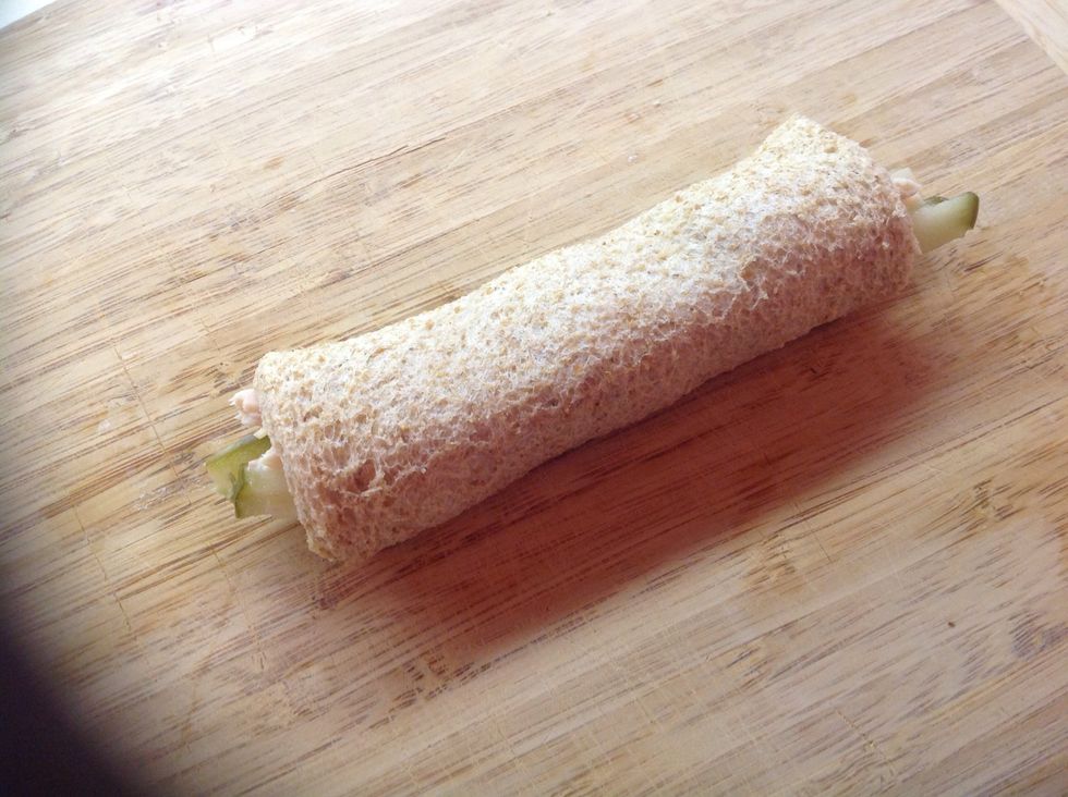 Starting with the long edge of the bread covered in tuna, gently roll into a tube. Lay the tube on the cutting board seam side down.