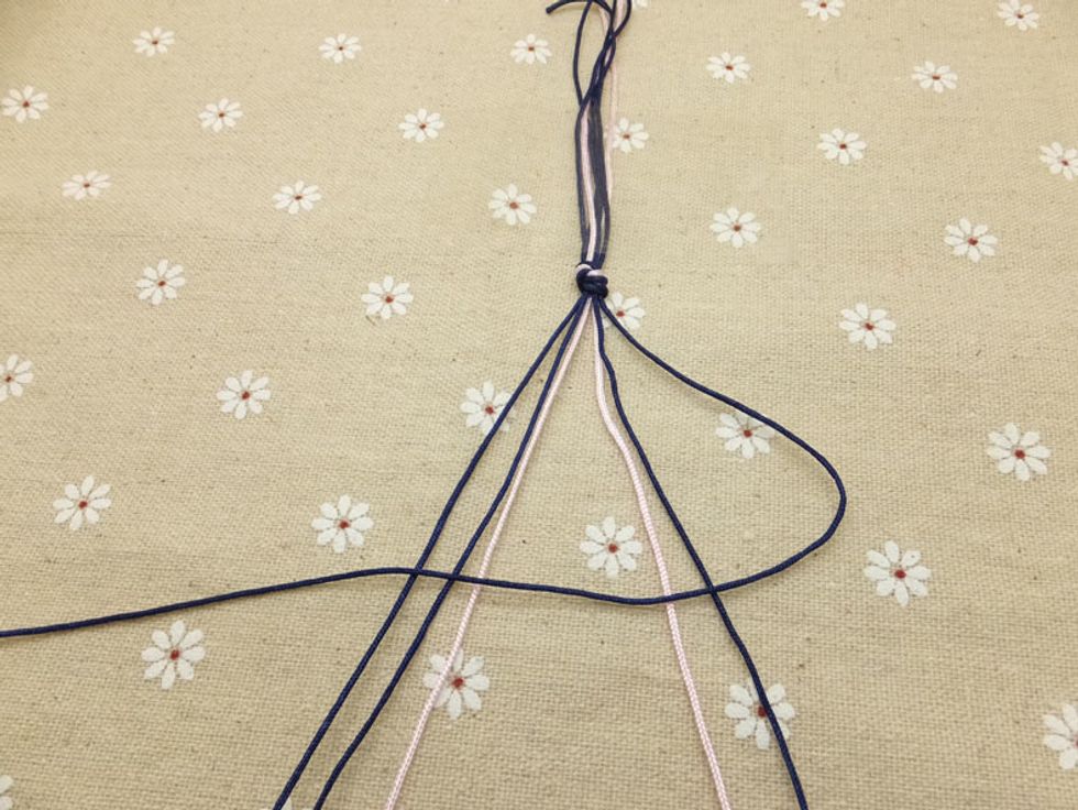 Starting with the outer-right cord, tie a backward knot make a ninety degree angle with the tying cord over the top of the cord you are tying it to. Note: Make the same knot twice on the adjacent cord