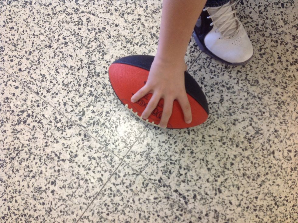 Step 1 Pick up football using one hand.