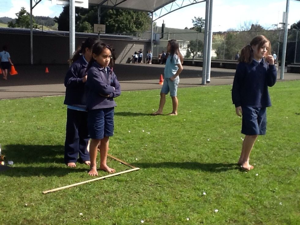 Step 1:  Stand behind the 1st metre ruler with a hacky sack / p\u00e9tanque.