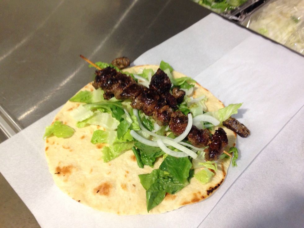 Step 10: Remove lamb skewer from grill and add onto top of toppings LAST.