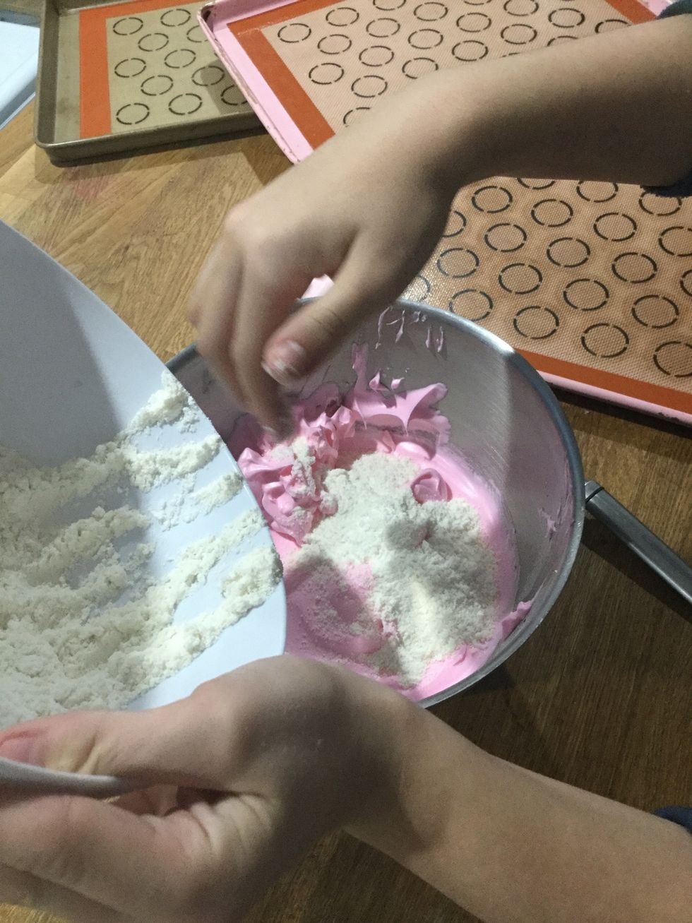 Step 10: Using a spatula, take 1/3 of the meringue and place it in the bowl of dry ingredients and gently mix them together until they are combined.