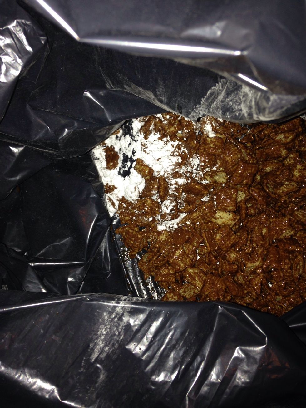 Step 18: Add in your Chex mixture with half a bag of confectioners sugar.