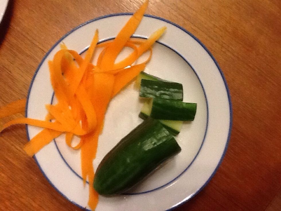 Step 2. Cut up the cucumber in to thin pieces. Then peel the carrot in to strips.