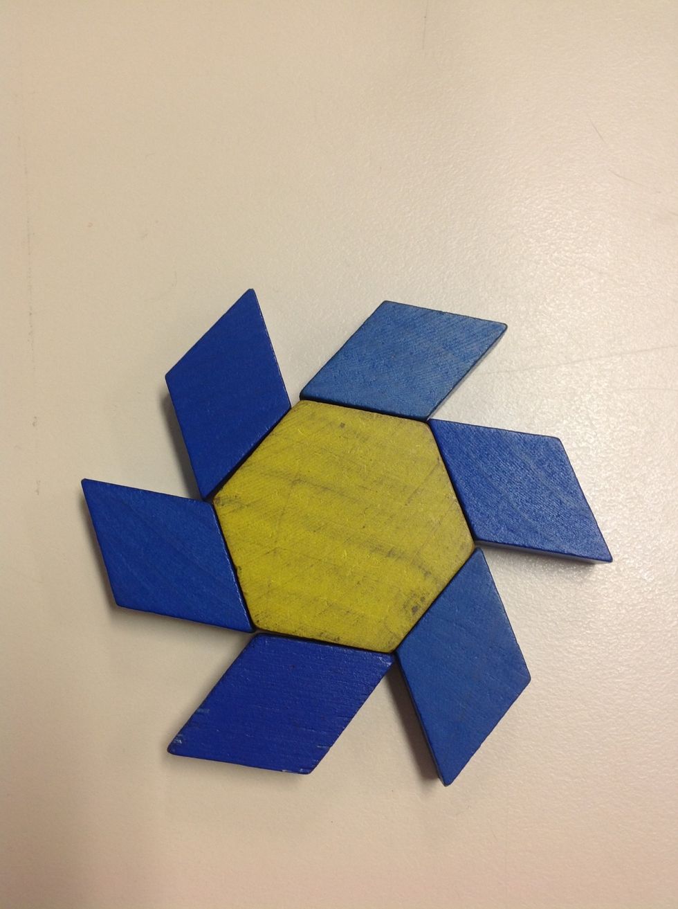 Step 2: Put main shape down in the centre. Tesselate shape by placing a specific colur and shape around the central shape.