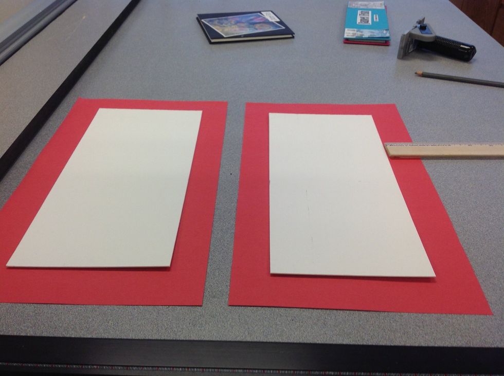 Step 2: Set the mat board on a sheet of colored paper that is large enough for a 1 1/2 inch border around the entire perimeter.