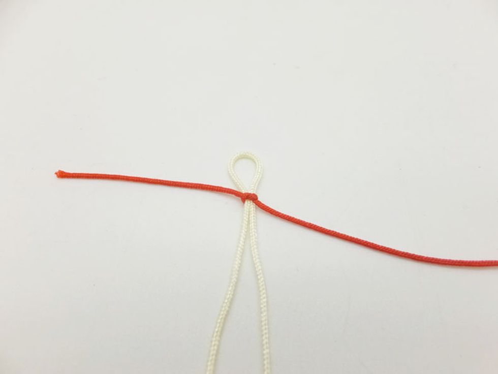 Step 2: Tie a small knot with the red cord.