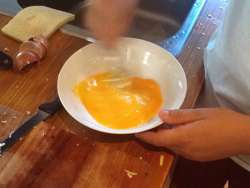 Step 2c) whisk the eggs in a bowl with a fork.