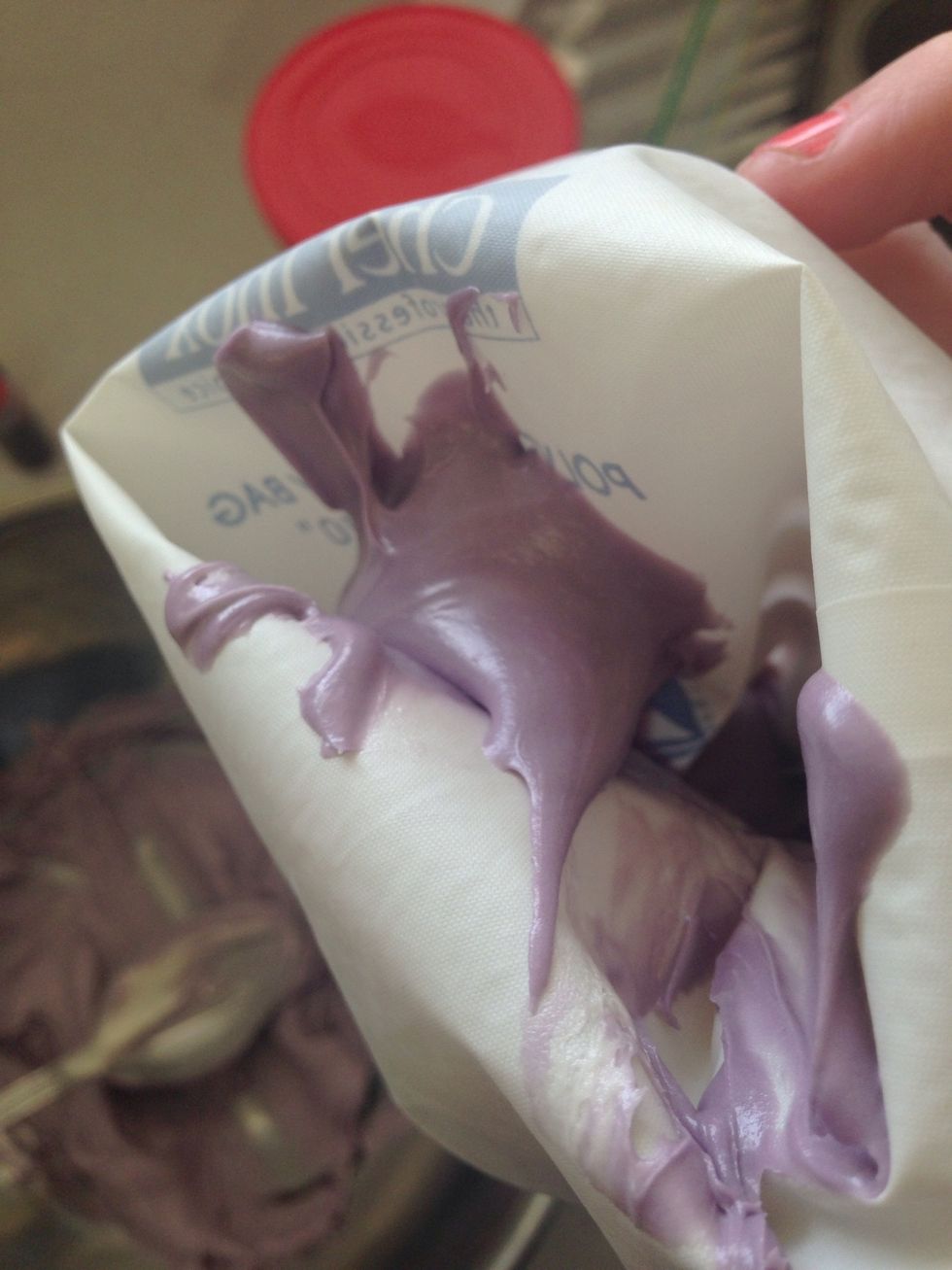 Step 3. Once you are happy with the colour spoon icing into a piping bag. You can use a zip lock back and cut the tip off. It doesn't matter if you don't have a nozzles or not