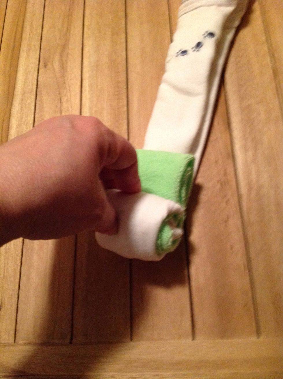 Step 3: you can add a wash cloth if you choose to add color. Place wash cloth at the end of the onesie and roll tightly until you reach the top then tie onesie with ribbon to hold in place...