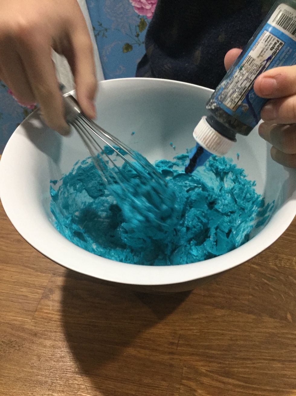 Step 32: When the buttercream is ready put it in another bowl and put a few drops of blue food colouring.