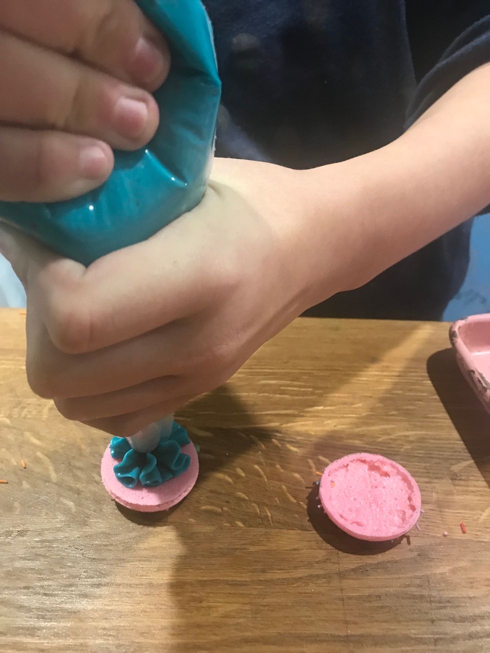 Step 37: Carefully put the other shell onto the buttercream, make sure you don\u2019t put the shell on all the way.