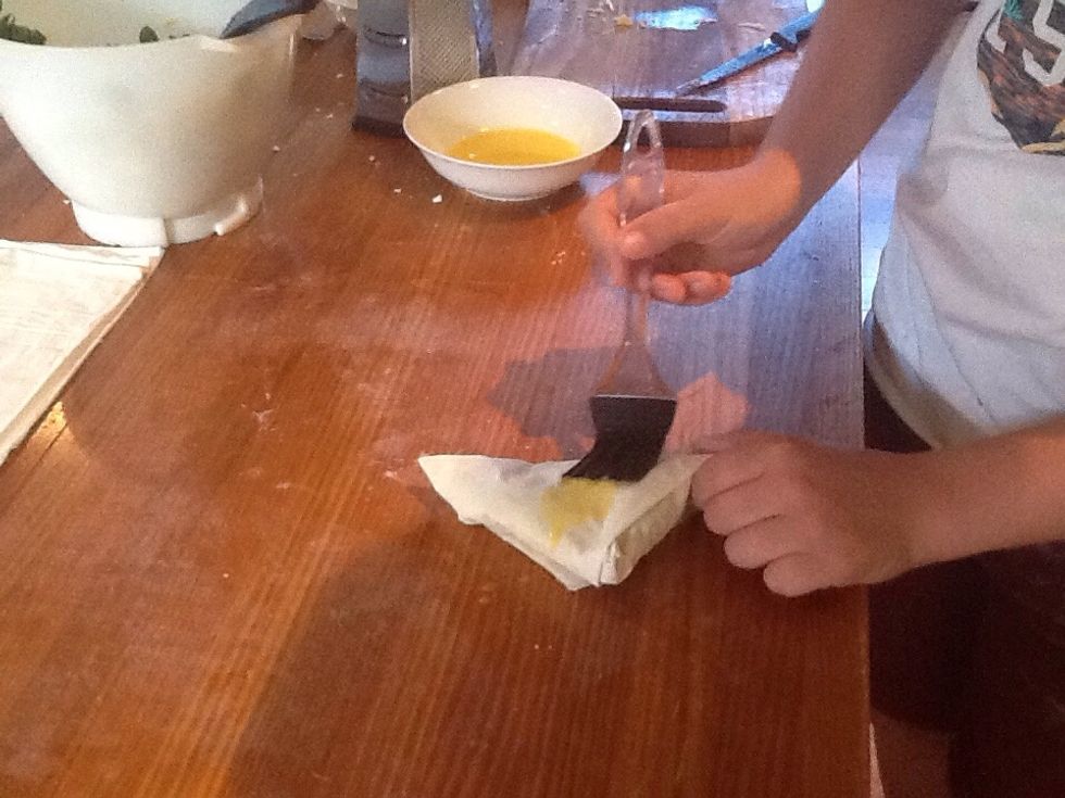 Step 4) brush the top of the triangle with butter using the pastry brush
