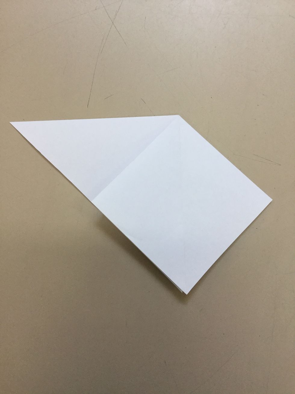 Step 4: Use your hands and grab one half of the big triangle and fold it inside out to make a sideways square in front of a triangle. Continue this on the other side.