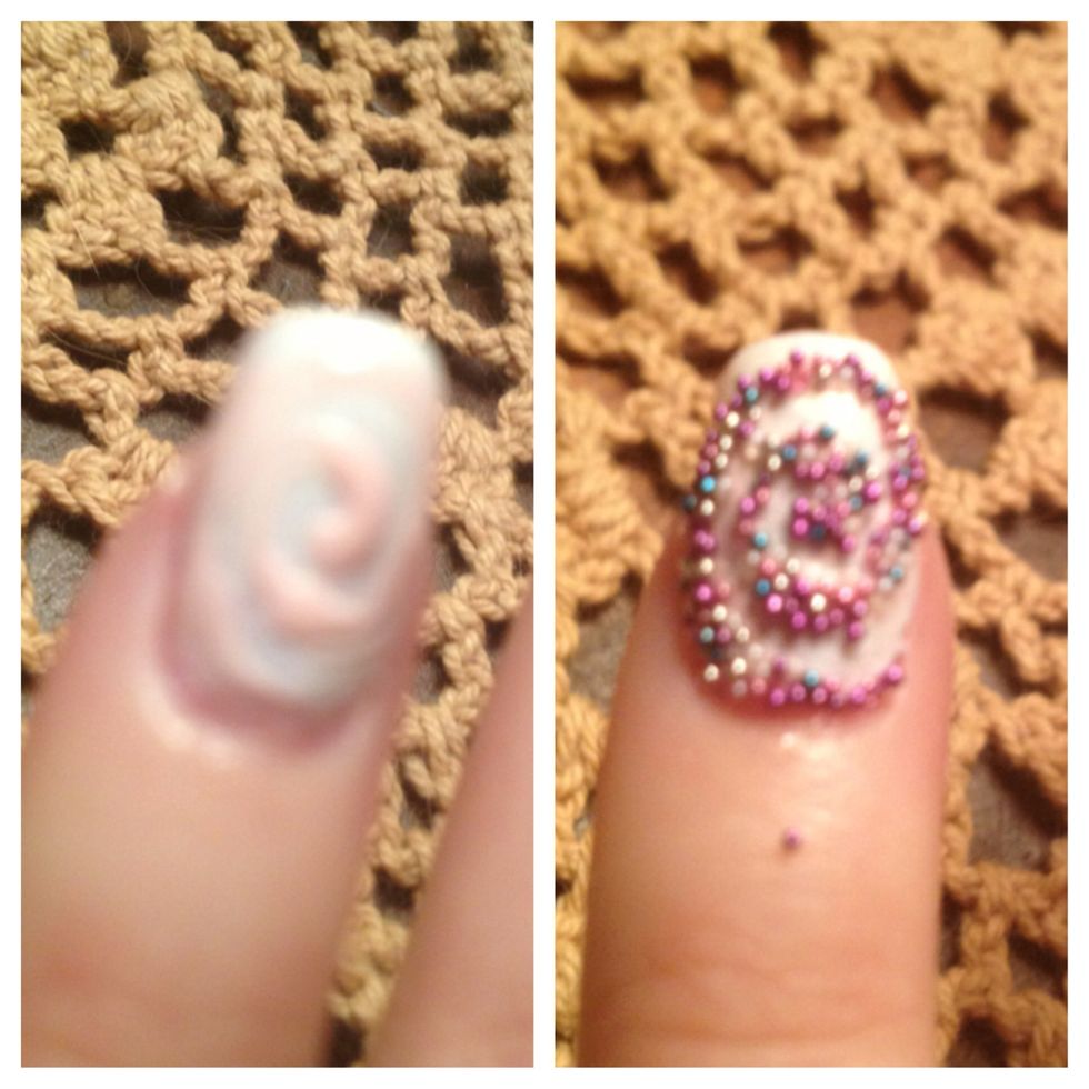 Step 5: Create swirl pattern with nail art striper brush on pinkie nail with nail polish (I used light pink polish that came with the kit). Dump beads on to the wet nail polish pattern.