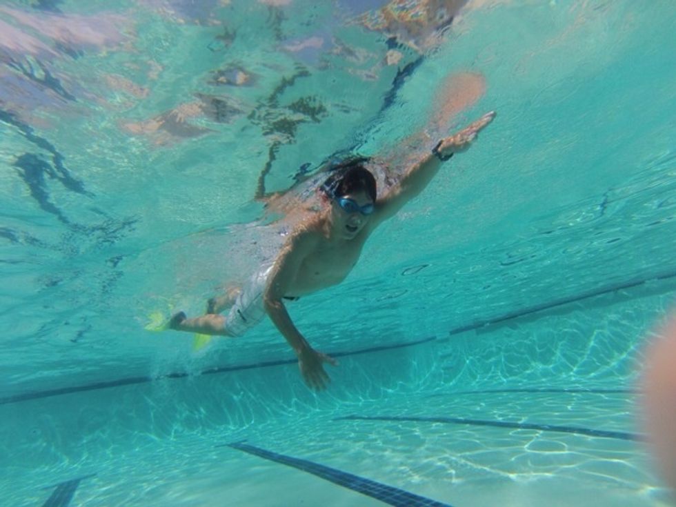 Step 5: Now that you are comfortable with the water practice simple freestyle strokes. Reach with your arm to grab the water and pull it back. Don't forget to keep kicking.