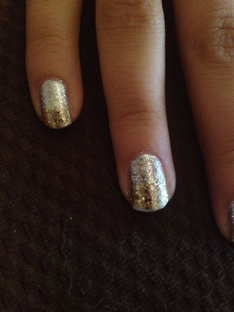 Step 5: Once silver glitter is dry, paint two coats on the top of the nail with the gold glitter nail polish