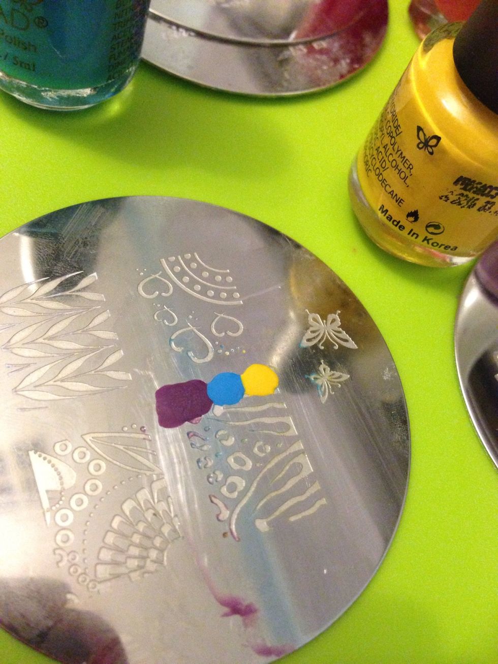 Step 5: place small drops at the side of your desired stamp colours on your plate. (Becareful! Don't let your brush touch the other colour) try placing the lighter colours before the darker colours