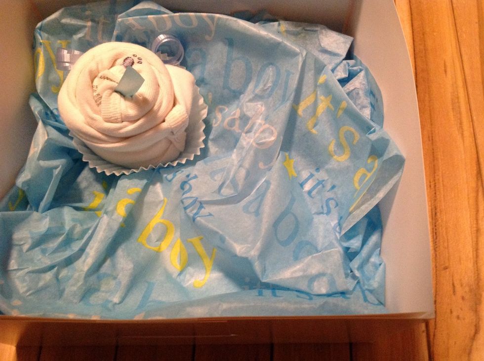 Step 5: Place your rolled up onesie into a cupcake cup ,then into the box. Continue the same steps with other onesies until you fill the box..