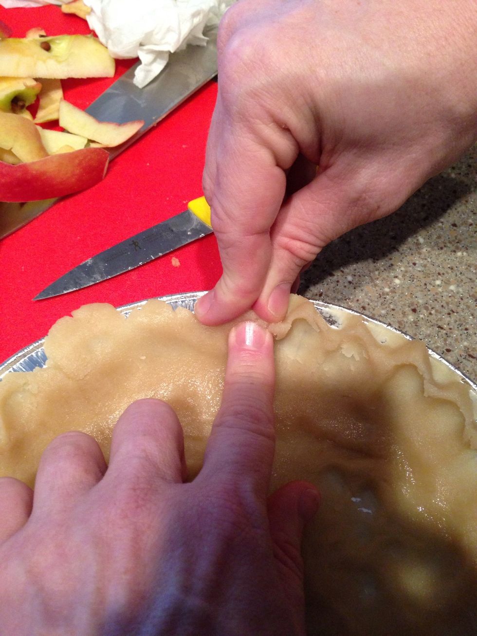 Step 5: Use 2/3 of the dough for the bottom of the crust. Gently push the crust into the pie plate (work the dough as little as possible). Use  your fingers like shown above to make a decorative trim.