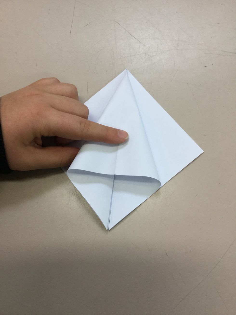 Step 5: Use your hands and grab one of the sides and flatten it down in the middle. Crease and continue on all sides.