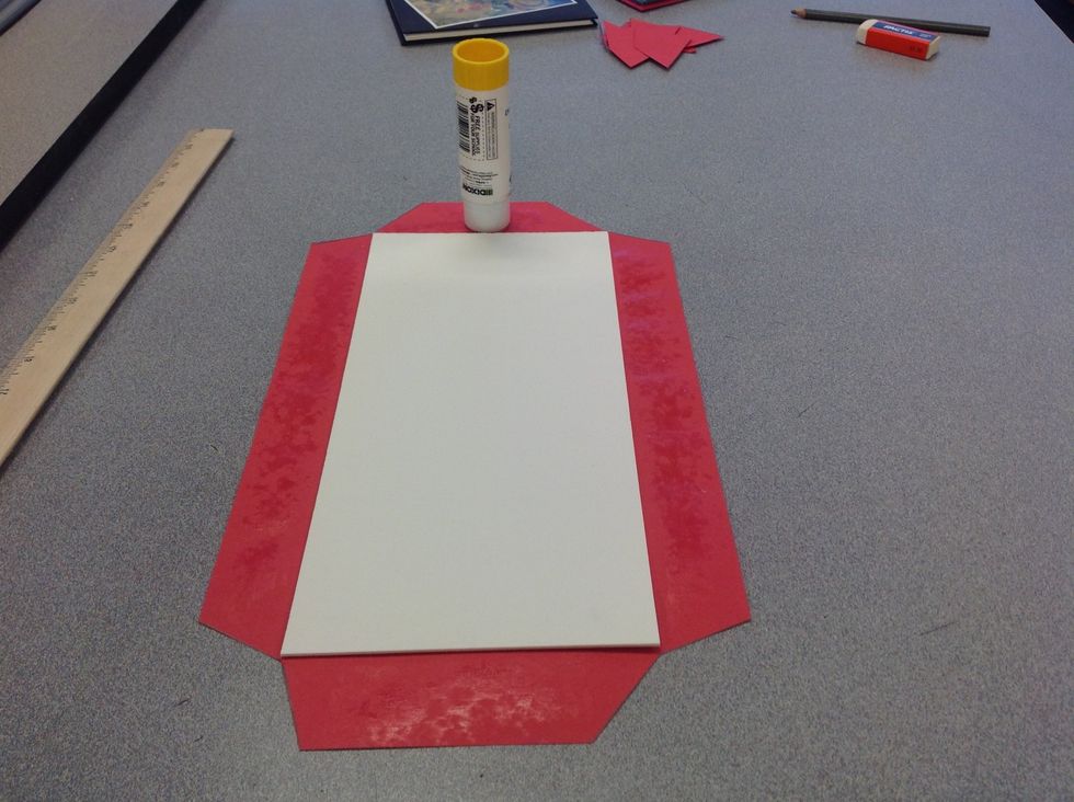 Step 6: Center the mat board inside the paper. Glue only the tabs to the cover by folding carefully around each side. Use a glue stick for best results.