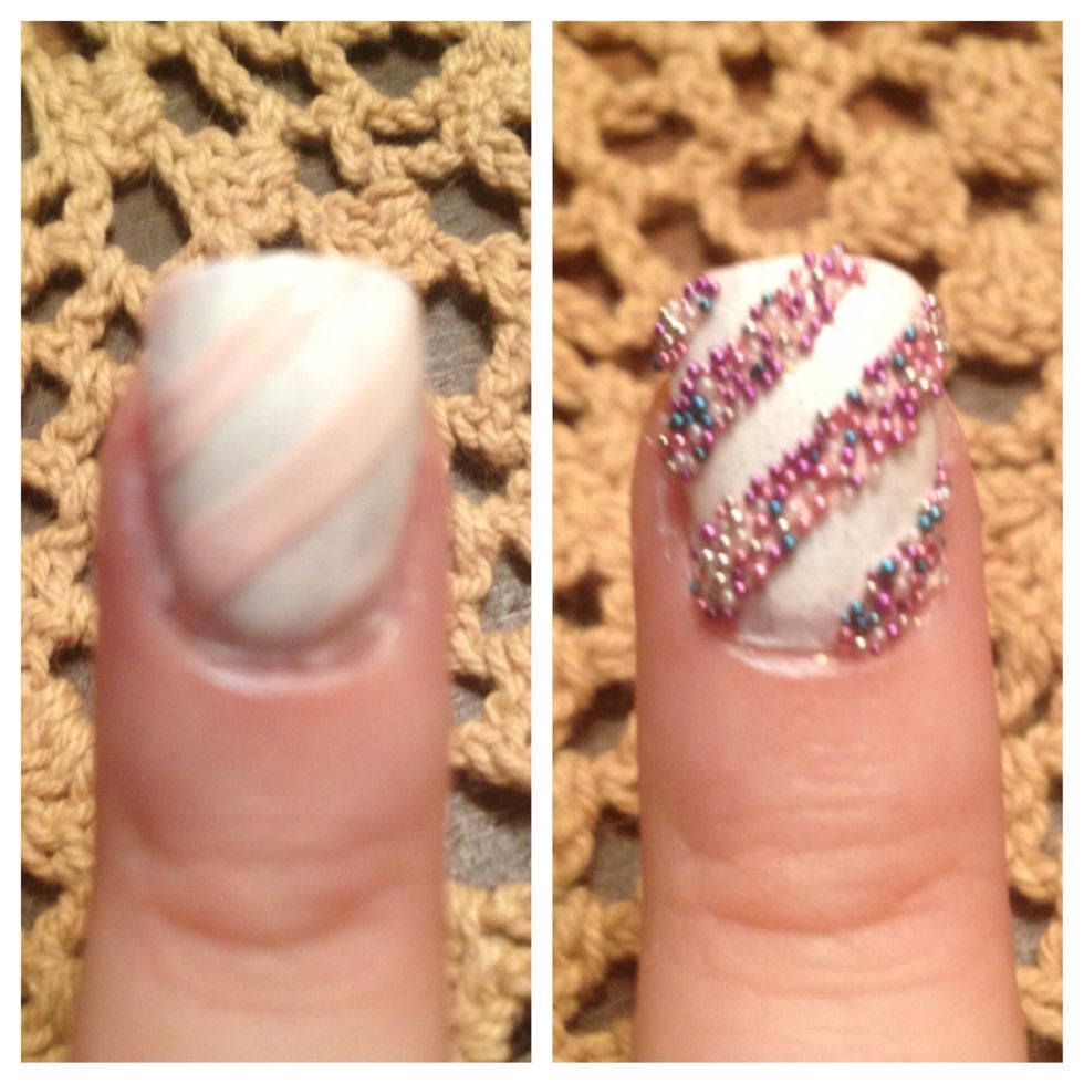 Step 6: Create diagonal pattern with nail art striper brush on middle nail with nail polish (I used light pink polish that came with the kit). Dump beads on to the wet nail polish pattern