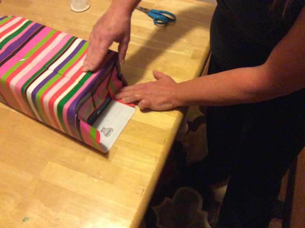 Step 6: Get the edges of the wrapping paper and fold the paper down almost like a triangle.