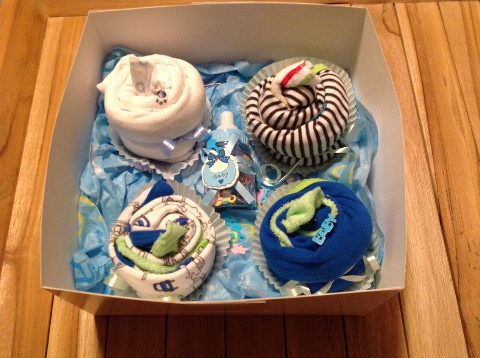 Step 6:Once you have finished, you can add baby toys, embellishments of your choice. Add confetti if you like. You can secure each cupcake onesie with 2sided tape on the tissue paper if you choose.