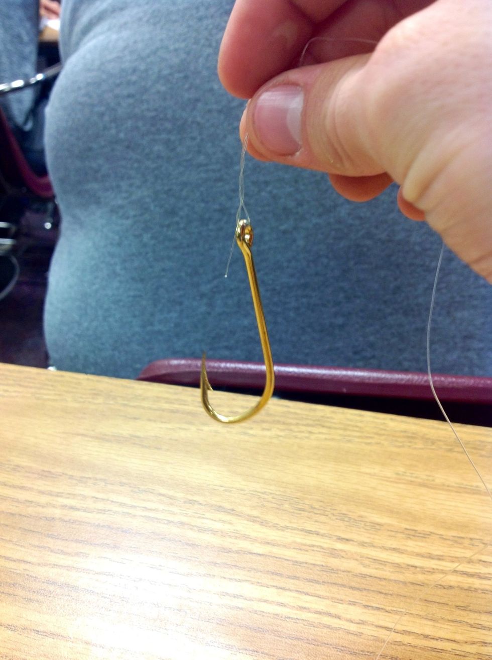 Step 6: Take the free end of the line in your right hand and feed it through the loop made closest to the eye of the hook