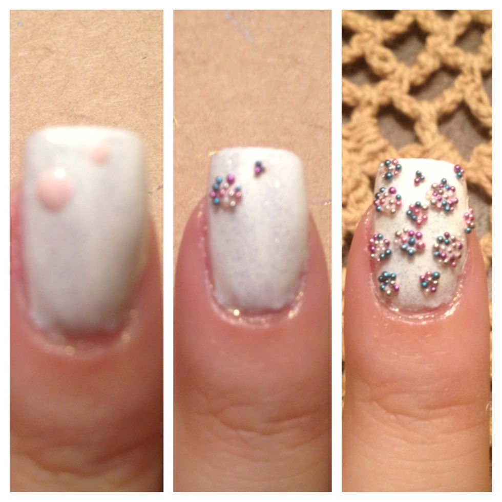 Step 7: Create dotted pattern with nail art dotting tool on pointer finger nail with nail polish (I used light pink polish that came with the kit). Dump beads on to the wet nail polish pattern