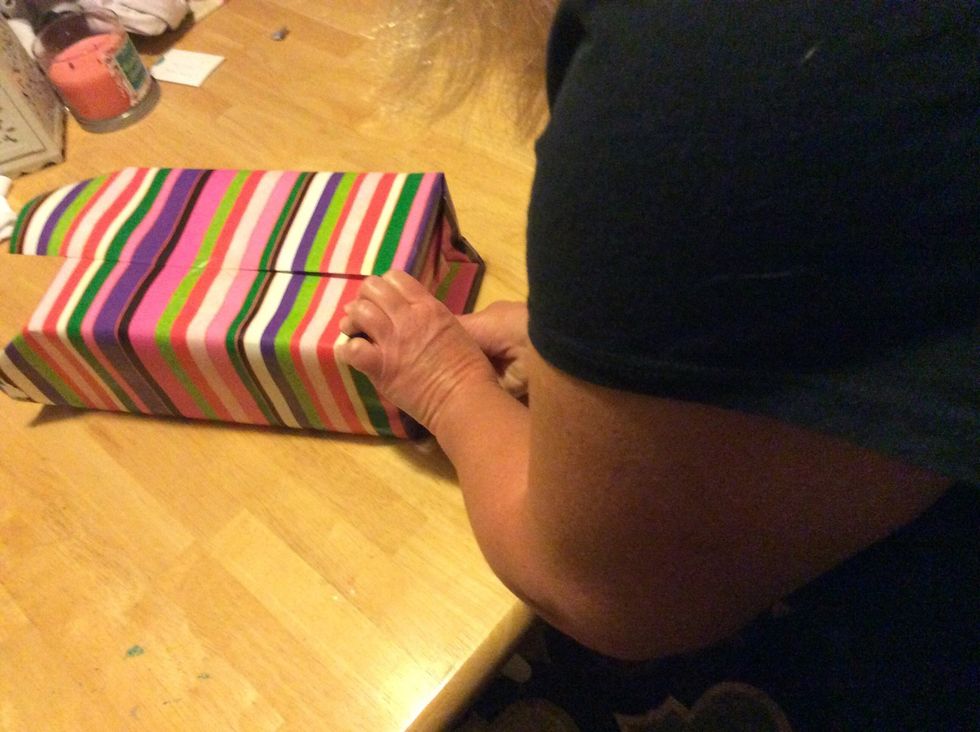 Step 7: Fold the edges up and tape it to the present. Repeat this step on the other side of the wrapping paper.