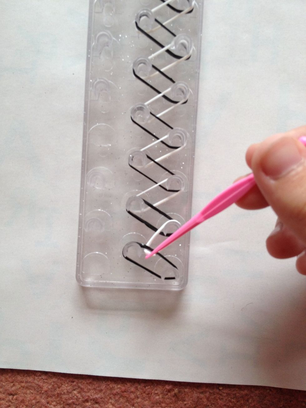 Step 7: now pick the second band (mines white) and loop it over the next peg