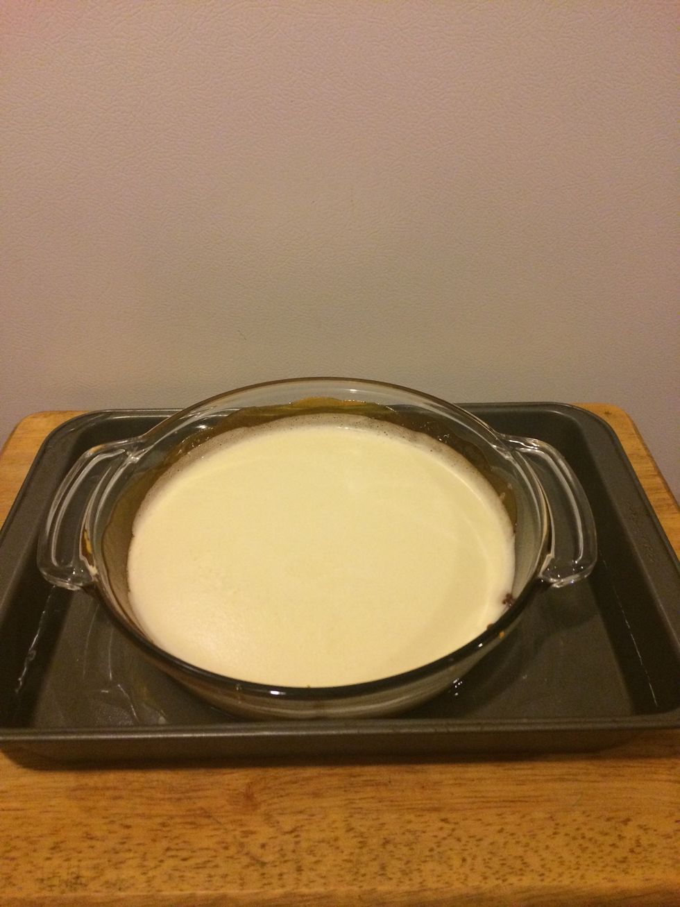 Step 7: Place the flan cooking dish in the center of the cake pan with water (this helps the heat evenly distribute and cook the flan right)