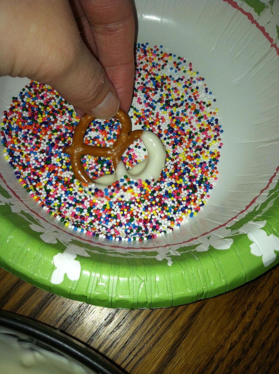 Step 8: Dip the pretzel in the sprinkles quickly.
